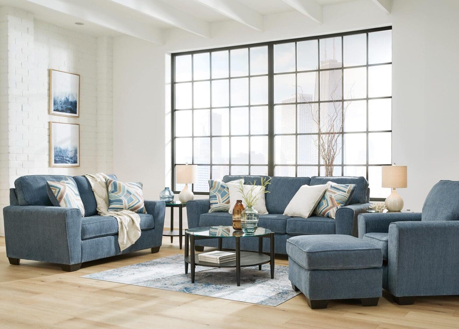 A living room with blue furniture and large windows.